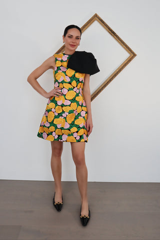 Saint Laurent black patent leather Blade ballerinas with gold chain detail, worn with a patterned dress.