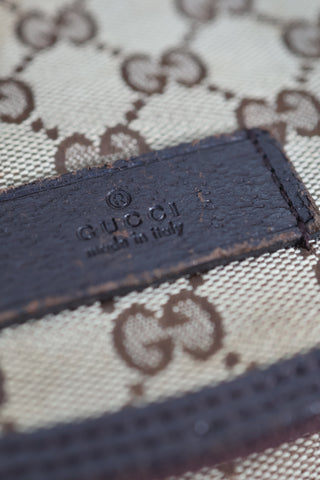 Gucci GG Canvas diaper bag in brown monogram canvas with leather trim and adjustable shoulder strap.