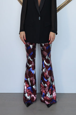 Nadine Merabi geometric sequin flare trousers in burgundy red, blue and silver with a high-waisted fit and statement flared leg silhouette.