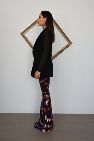 Nadine Merabi geometric sequin flare trousers in burgundy red, blue and silver with a high-waisted fit and statement flared leg silhouette.