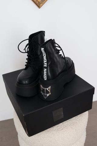 Naked Wolfe Saturn black leather platform lace-up ankle boots in Size 8 featuring a 160mm platform sole, metallic Wolfe head heel detail and signature NAKED WOLFE branding, displayed with the original box and tags.