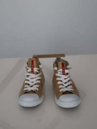 Prada toddler beige patent leather high-top sneakers with lace-up and side zip closure.