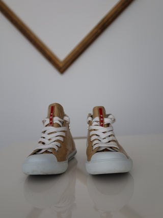 Prada toddler beige patent leather high-top sneakers with lace-up and side zip closure.