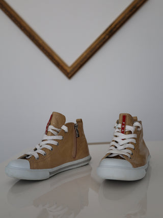 Prada toddler beige patent leather high-top sneakers with lace-up and side zip closure.