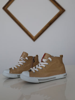 Prada toddler beige patent leather high-top sneakers with lace-up and side zip closure.