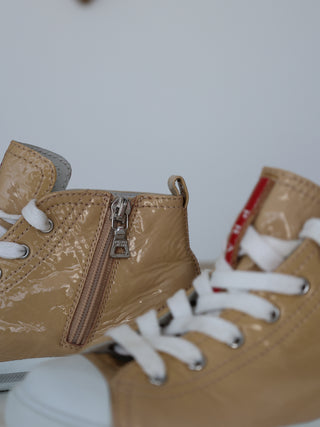 Prada toddler beige patent leather high-top sneakers with lace-up and side zip closure.