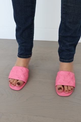 Louis Vuitton candy pink lambskin monogram mules, size 38, photographed on model showing embossed strap and slim heel.