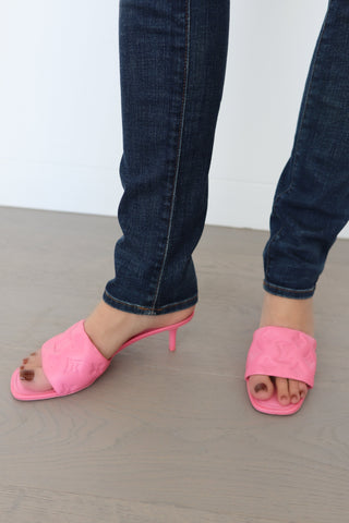Louis Vuitton candy pink lambskin monogram mules, size 38, photographed on model showing embossed strap and slim heel.