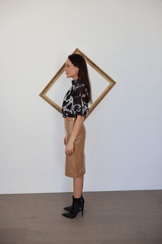 Adam Lippes black sheer blouse with white architectural print photographed on model.