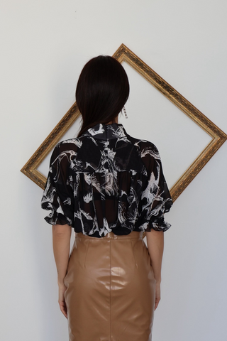 Adam Lippes black sheer blouse with white architectural print photographed on model.
