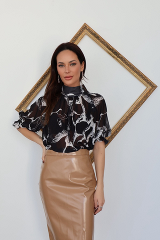 Adam Lippes black sheer blouse with white architectural print photographed on model.