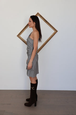 Side angle of Zimmermann striped one-shoulder mini dress displaying the draped silhouette and vertical stripe placement