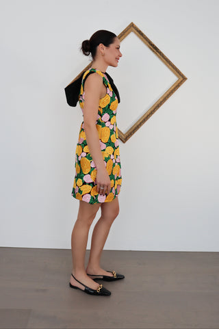 Model wearing Rachel Gilbert embroidered floral knee-length dress with oversized black shoulder bow.