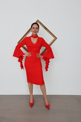Woman wearing a red Carla Zampatti midi dress with dramatic tiered sleeve and V neckline.