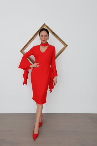 Woman wearing a red Carla Zampatti midi dress with dramatic tiered sleeve and V neckline.