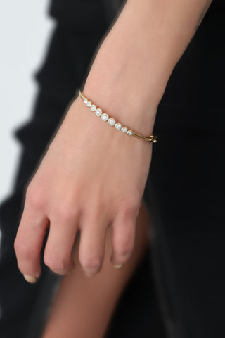 Michael Hill 10K yellow gold diamond bezel-set bangle with round brilliant diamonds.