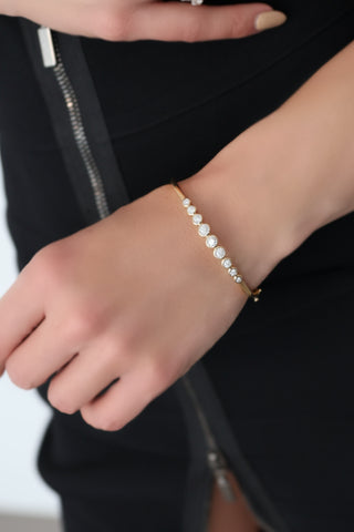 Michael Hill 10K yellow gold diamond bezel-set bangle with round brilliant diamonds.