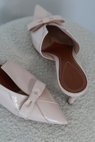 Zimmermann cream patent leather pointed toe mules with bow detail and mid-height heel.