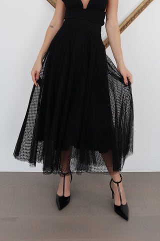 Black Zimmermann polka-dot tulle maxi skirt styled with pointed black heels, showing layered mesh detail.