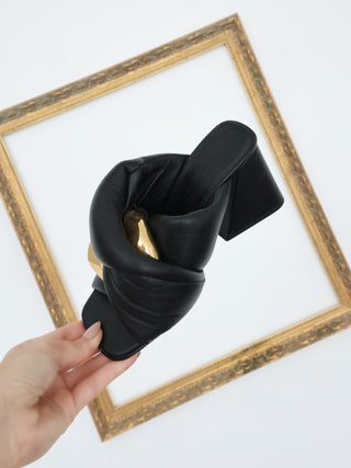 JW Anderson black leather Chain Twist mule with oversized gold chain detail and block heel, photographed from multiple angles.