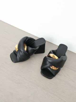 JW Anderson black leather Chain Twist mule with oversized gold chain detail and block heel, photographed from multiple angles.