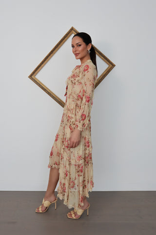 Model wearing Zimmermann floral midi dress in neutral tones with pink flowers, standing against a white background with a tilted gold frame.