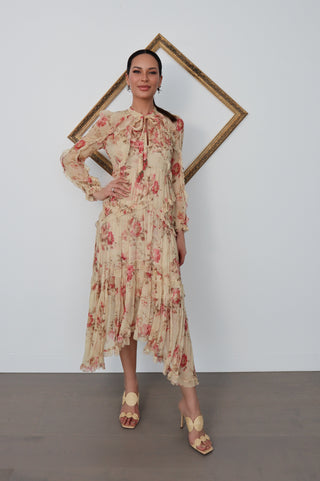 Model wearing Zimmermann floral midi dress in neutral tones with pink flowers, standing against a white background with a tilted gold frame.