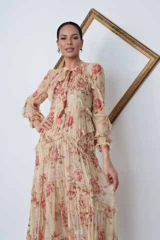 Model wearing Zimmermann floral midi dress in neutral tones with pink flowers, standing against a white background with a tilted gold frame.