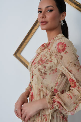 Model wearing Zimmermann floral midi dress in neutral tones with pink flowers, standing against a white background with a tilted gold frame.