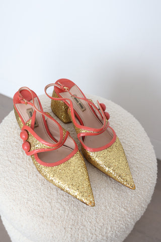Miu Miu gold glitter pointed-toe pumps in EU Size 40 featuring coral-orange patent leather crossover straps, sculptural button embellishments and glitter-covered low block heels.