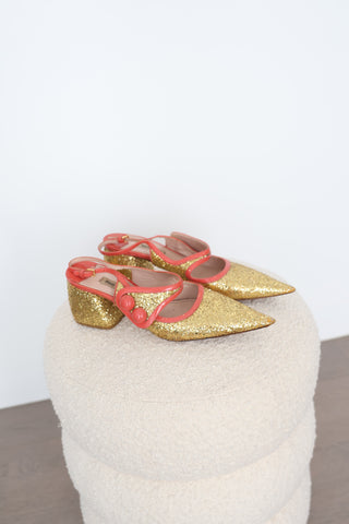 Miu Miu gold glitter pointed-toe pumps in EU Size 40 featuring coral-orange patent leather crossover straps, sculptural button embellishments and glitter-covered low block heels.