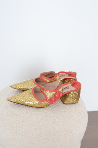 Miu Miu gold glitter pointed-toe pumps in EU Size 40 featuring coral-orange patent leather crossover straps, sculptural button embellishments and glitter-covered low block heels.