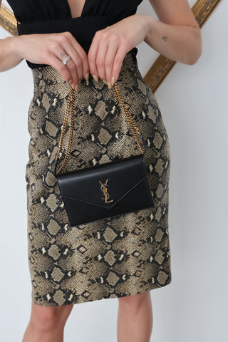 A timeless Saint Laurent classic, the Small Envelope Wallet on Chain is a refined essential crafted from smooth black leather and finished with the iconic gold-toned YSL monogram.